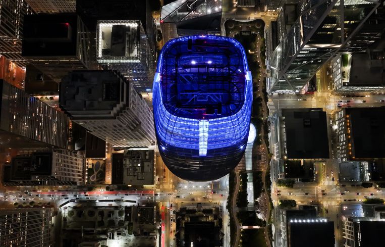 An aerial night view of Salesforce Tower and buildings in San Francisco.