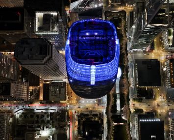 An aerial night view of Salesforce Tower and buildings in San Francisco.