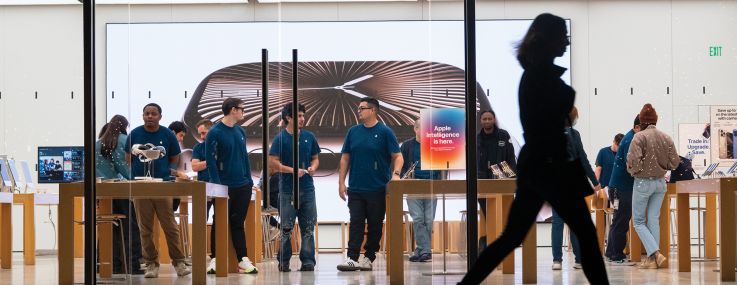 A shopper passing by an Apple store.