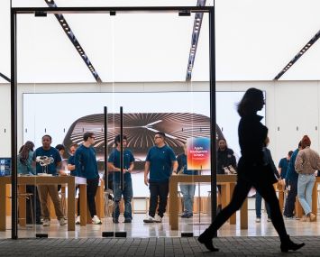 A shopper passing by an Apple store.