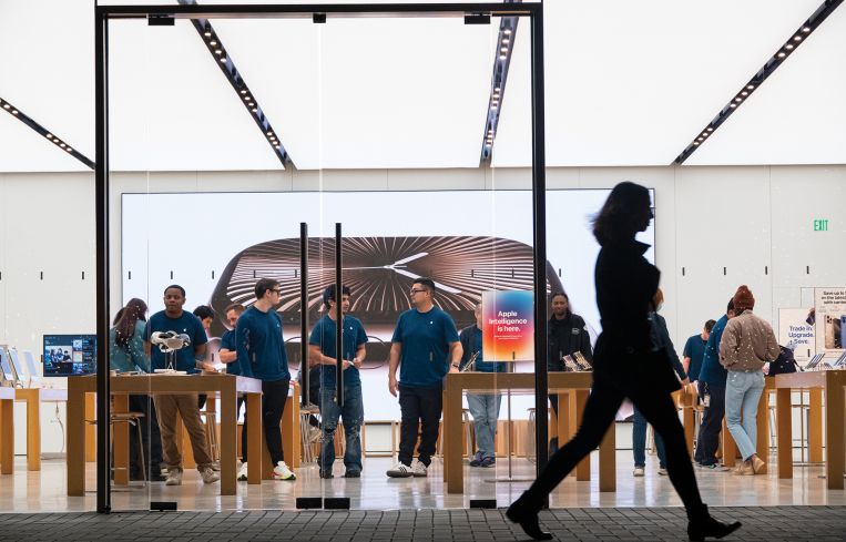 A shopper passing by an Apple store.