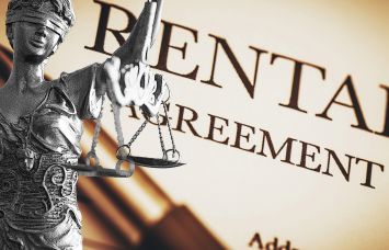 A photo of a Lady Justice statue overlayed on a rental agreement.