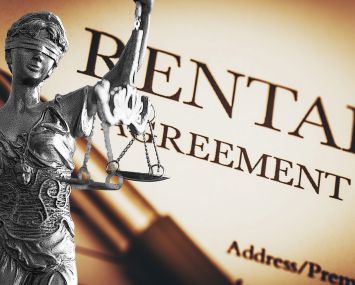 A photo of a Lady Justice statue overlayed on a rental agreement.