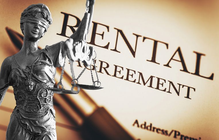 A photo of a Lady Justice statue overlayed on a rental agreement.
