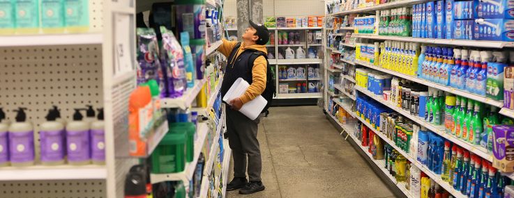 A lone shopper in the aisle of a department store.