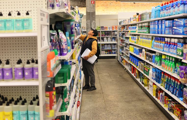 A lone shopper in the aisle of a department store.
