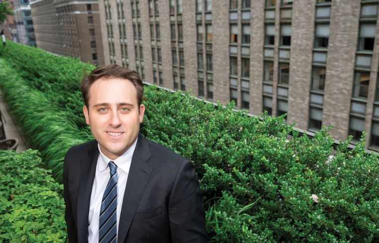 Henry Fenmore of CBRE poses for a portrait on a terrace at the company's office.