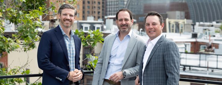 Three men standing on a rooftop.