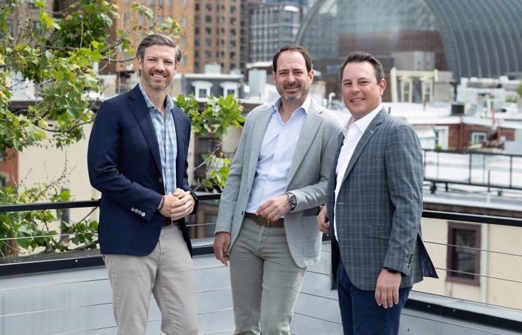 Three men standing on a rooftop.