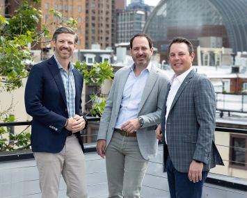 Three men standing on a rooftop.