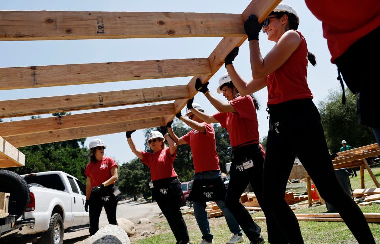 Volunteers with San Gabriel Valley Habitat for Humanity on June 26 help construct walls which will be used to build new homes for Altadena Eaton Fire victims in Pasadena, California.