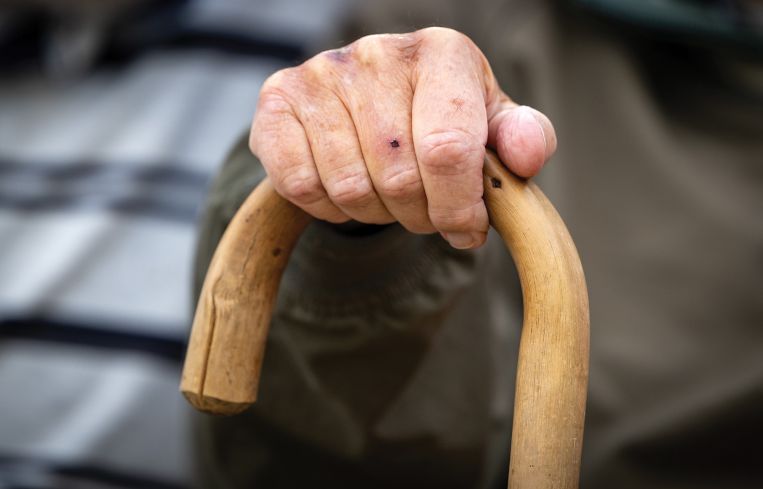 A close-up of a hand on a cane.