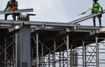 Construction workers help build a mixed-use apartment complex in Los Angeles, Calif.