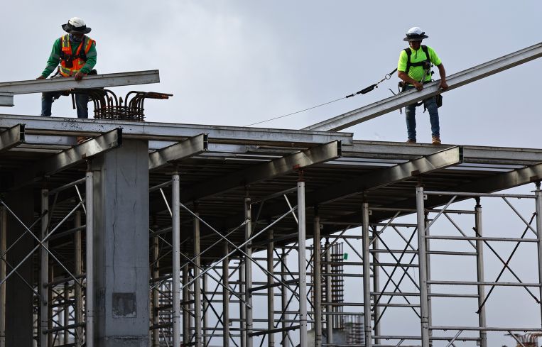 Construction workers help build a mixed-use apartment complex in Los Angeles, Calif.