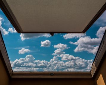 View of clouds in sky through open window.