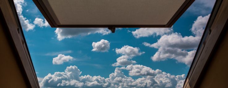 View of clouds in sky through open window.