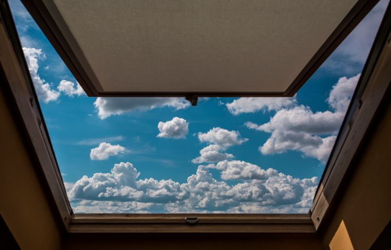 View of clouds in sky through open window.