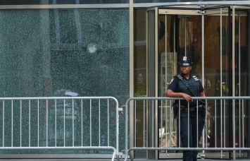 A New York City Police (NYPD) officer stands outside the 345 Park Avenue building, the scene of deadly shootings in Midtown Manhattan.