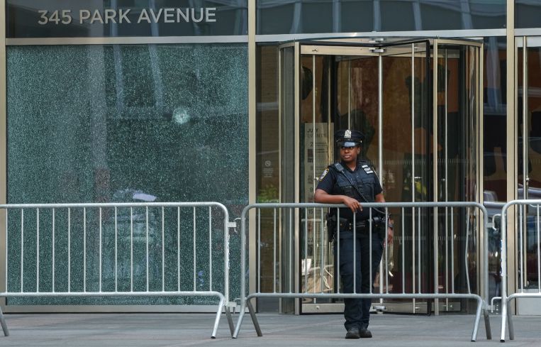 A New York City Police (NYPD) officer stands outside the 345 Park Avenue building, the scene of deadly shootings in Midtown Manhattan.