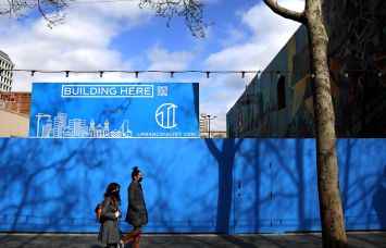 Pedestrians walk past a site to be constructed by Urban Catalyst in San Jose, Calif.