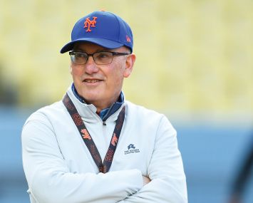 A man in a Mets cap with his arms folded.