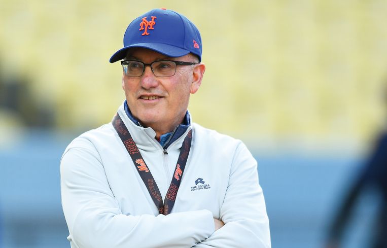 A man in a Mets cap with his arms folded.