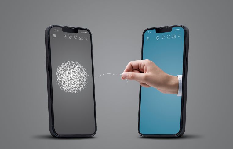 Two smartphones facing each other, a hand is untangling a line on the other screen, online therapy concept.