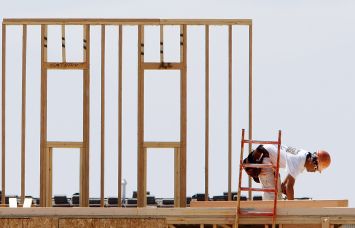 A construction worker builds housing.