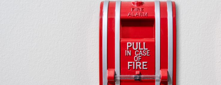 A wall-mounted fire alarm pull station.