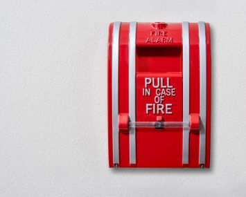 A wall-mounted fire alarm pull station.