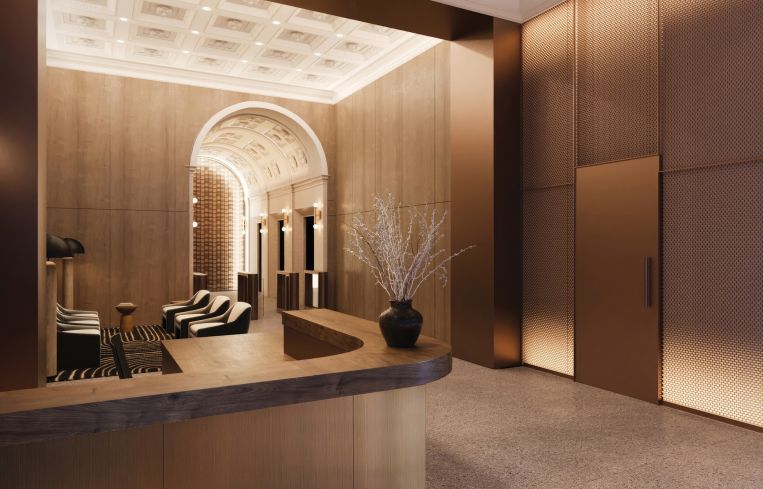 The lobby features a warmly lit archway that leads to the elevator banks adjacent to the waiting area.