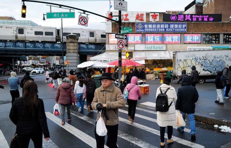 People walk in a street of Flushing, Queens.