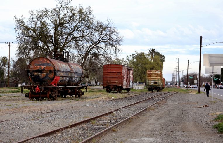 A vacant lot except for three old train cars.