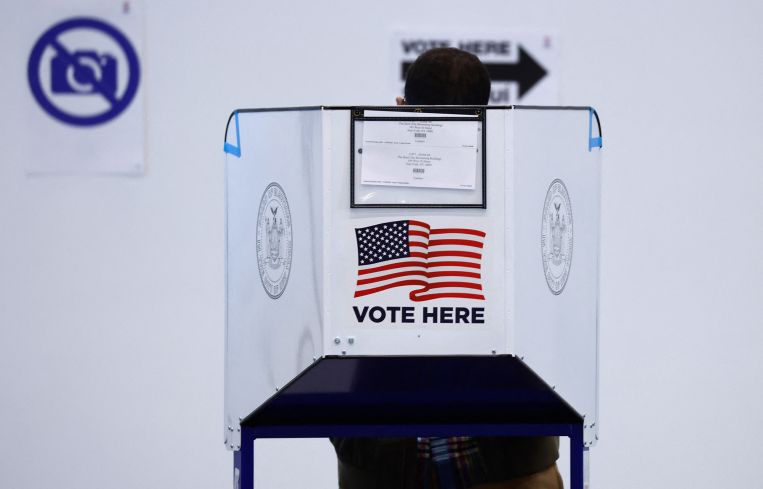 A voter casts their ballot at a polling station in the Bloomberg building at Hudson Yards during the first day of early in New York on October 26, 2024.