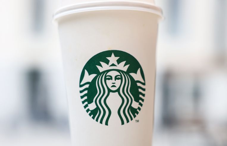 A frowning Starbucks logo on a coffee cup.