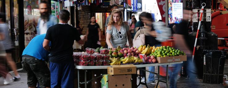A street vendor sells fruit along Roosevelt Avenue in Queens.