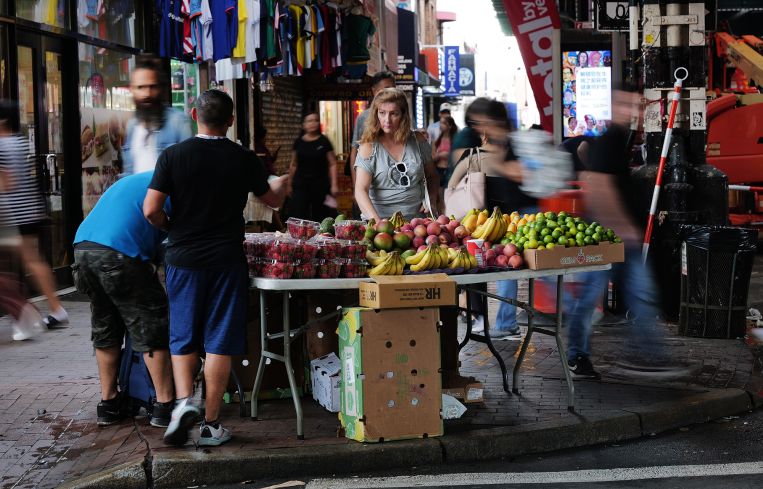 A street vendor sells fruit along Roosevelt Avenue in Queens.