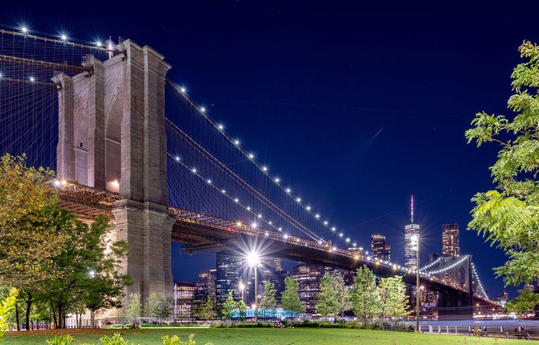 NEW YORK, NEW YORK - AUGUST 23: A view of the Brooklyn Bridge with the One World Trade Center in the back as part of the downtown Manhattan skyline as seen from Brooklyn Bridge Park on August 23, 2022 in New York City.