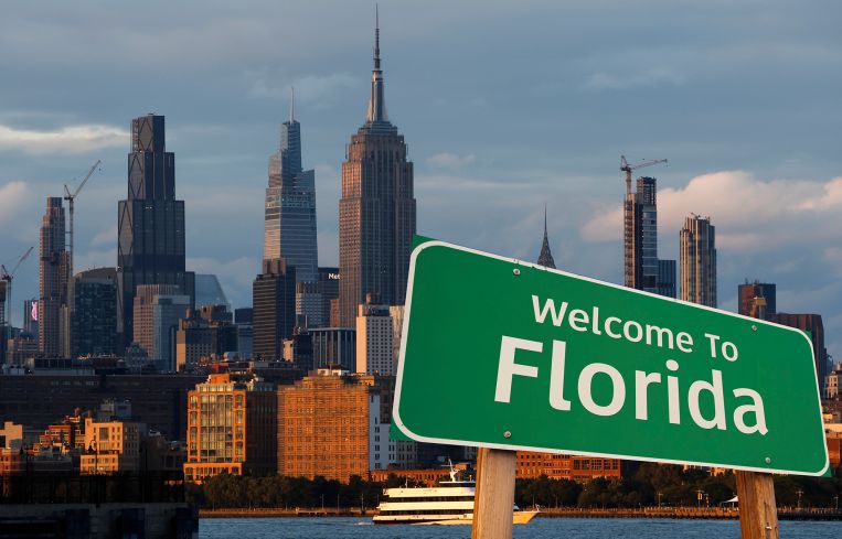 A Welcome to Florida sign in front of the New York City skyline.