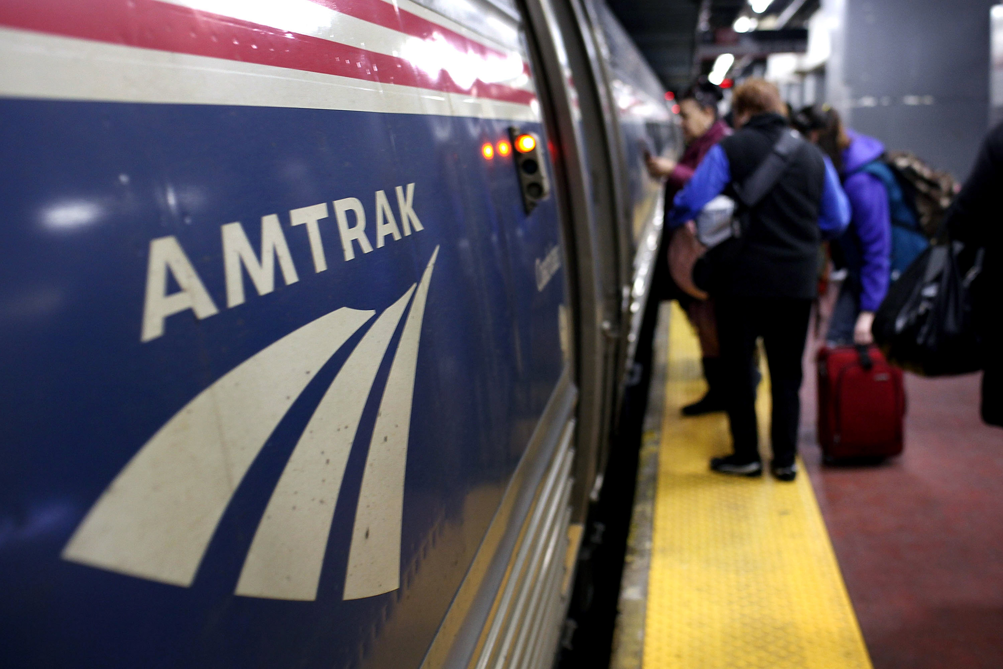 People board an Amtrak train at Penn Station.