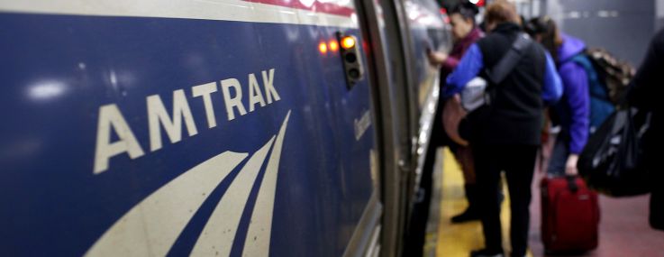 People board an Amtrak train at Penn Station.