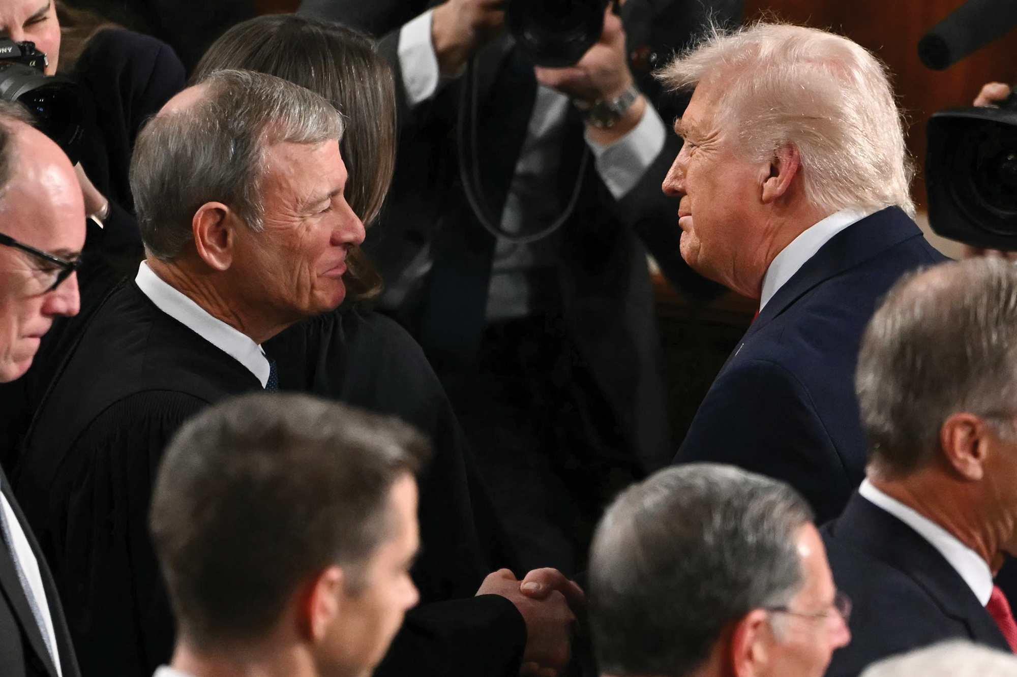 Supreme Court Chief Justice John Roberts (left) shakes hands with President Donald Trump as he arrives to deliver his State of the Union address.