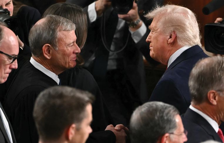 Supreme Court Chief Justice John Roberts (left) shakes hands with President Donald Trump as he arrives to deliver his State of the Union address.