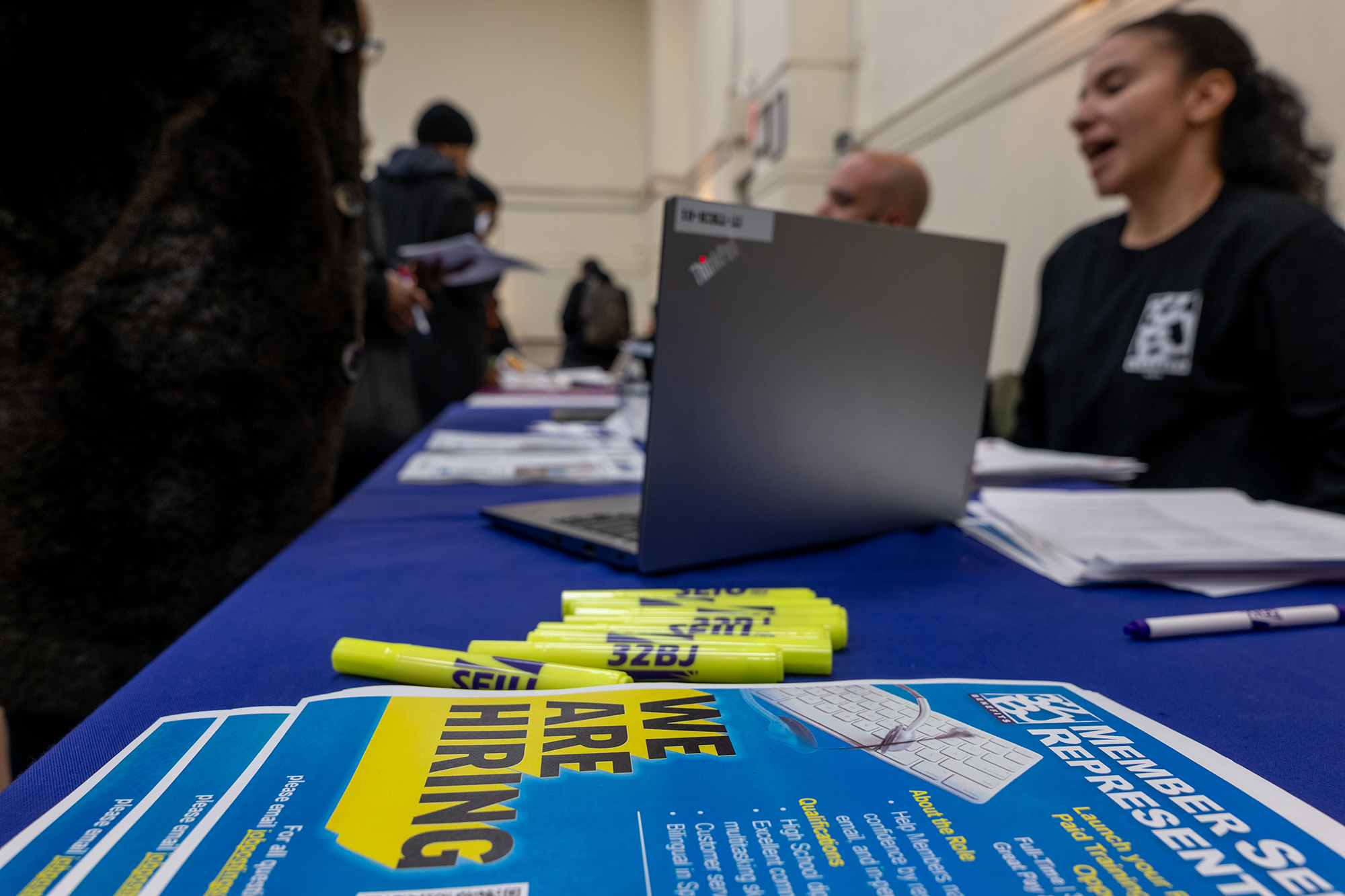 Business representatives staff a table at a career fair in Harlem.