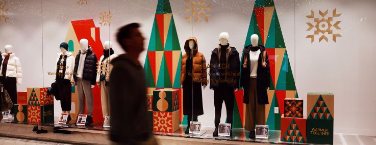 A person walks through a mall decorated with holiday lights in Manhattan in December.