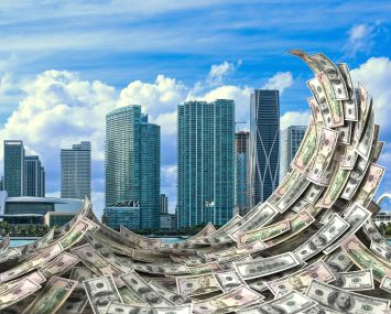Miami skyline with a wave of dollar bills in front of it.