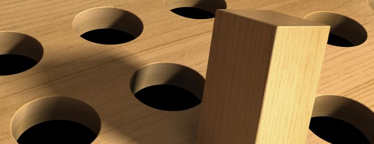 An illustration of a square peg forced into a round hole.