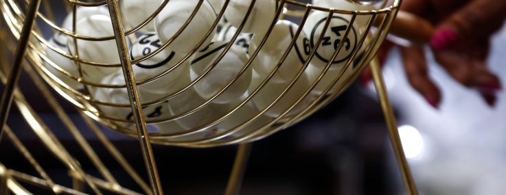 A bingo ping-pong ball rolls out of a hopper.