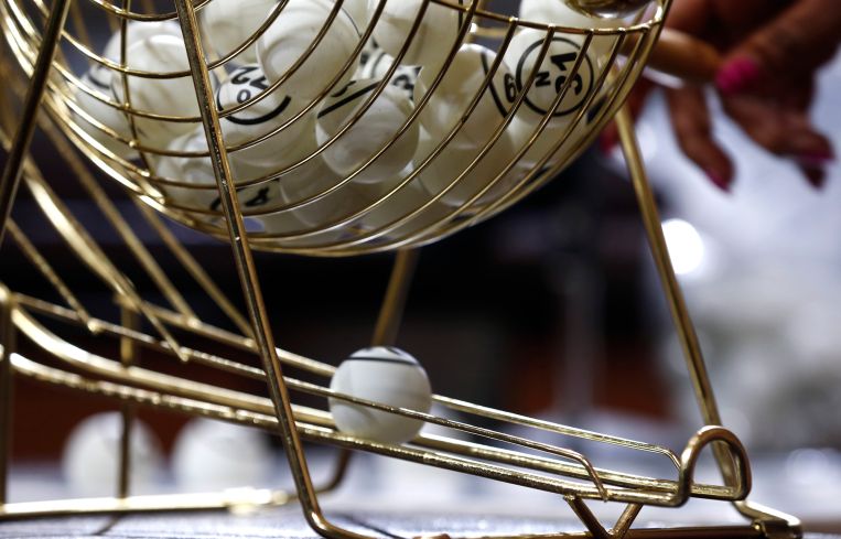 A bingo ping-pong ball rolls out of a hopper.