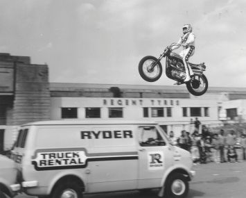 Evel Knievel practising jumping over three vans in the car park of Wembley Stadium.